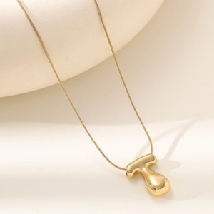 Detailed macro view of 18K gold-plated T-shaped pendant on a sleek snake chain