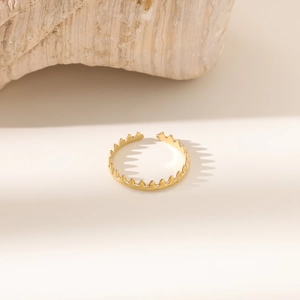 Detail eines goldenen Vintage-Kronenrings mit poliertem Finish auf Steinoberfläche