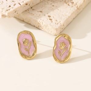 Detail of vintage French gold oval stud earrings with pink enamel and tulip embossing
