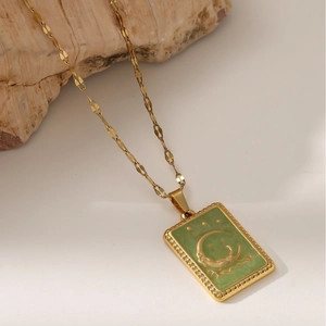Dettaglio macro della collana di tarocchi vintage dorata con ciondolo luna e stelle e catena