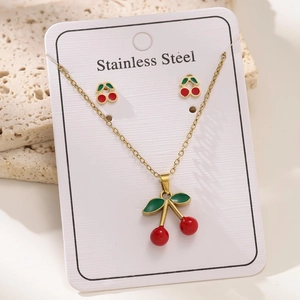 Vue macro d'une parure bijoux cerise en acier inoxydable plaqué or 18 carats avec collier