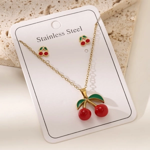 Vue macro détaillée du parure collier et boucles d'oreilles cerise en acier doré 18 carats