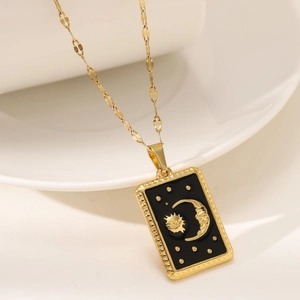 Golden tarot sun and moon pendant necklace with black enamel detail on sleek twist chain