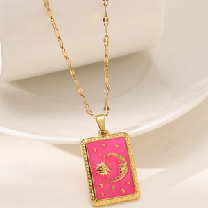 Macro detail of gold tarot necklace with pink enamel and sun moon embossed pendant