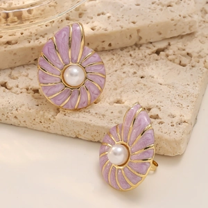 Macro detail of gold conch stud earrings with lavender enamel and centered white pearl