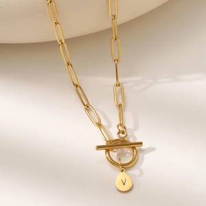 Detailed close-up of a golden paperclip chain necklace with a letter V pendant and toggle clasp