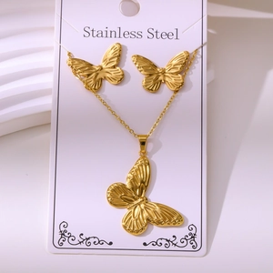 Macro view of butterfly jewelry set showing detailed wing texture on stainless steel