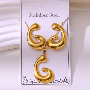 Detail of vintage gold-plated stainless steel jewelry set with spiral pendant earrings