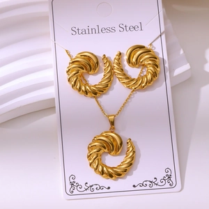 Macro detail of gold stainless steel jewelry set with elegant spiral twist textures