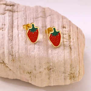 Close-up of strawberry fruit stud earrings with red enamel and gold metal base