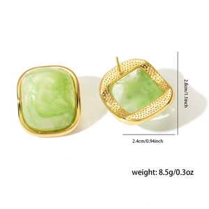 Detailed view of square light green resin earrings with golden hammered metal texture