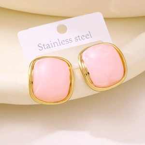 Detail view of pink resin square stud earrings with polished gold stainless steel frame