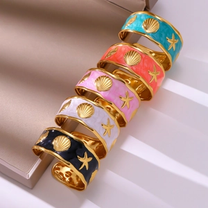 Open armband met zeester en schelp in kleurrijk marmeren emaille met gouden afwerking