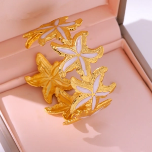 Détail d'un bracelet étoile de mer en émail blanc posé dans un écrin à bijoux rose