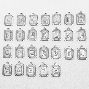 Set de 26 colgantes cuadrados de acero inoxidable con textura radial en fondo blanco