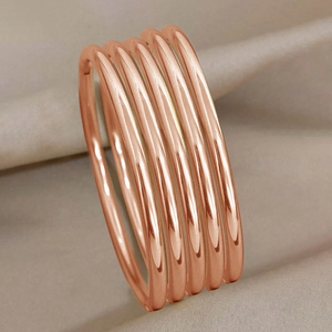 Minimalist 3mm rose gold stackable stainless steel bangles set on silk fabric