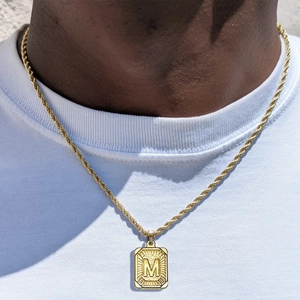 Detalle del colgante cuadrado letra M bañado en oro de 18k con cadena de cordón