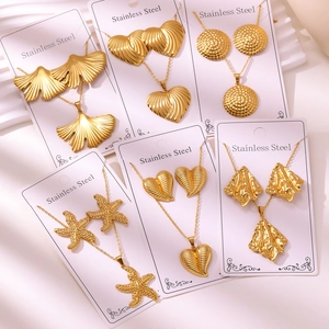 Detailed flat lay of assorted 18K gold-plated stainless steel leaf and heart jewelry sets