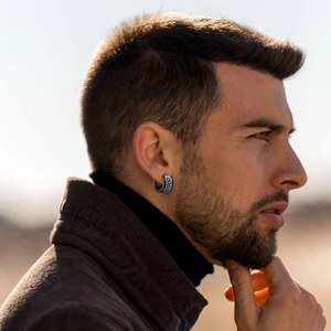 Close-up of men's stainless steel hoop earring with black Greek key pattern on male model