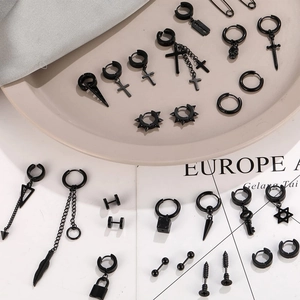 Macro shot of 28-piece black punk earrings set with cross and skull charms on beige props