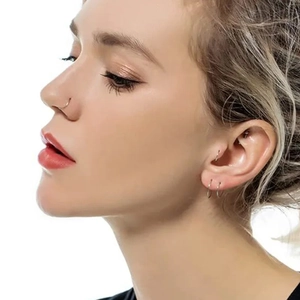 Gold twist stainless steel seamless rings worn on nose, tragus, and earlobe cartilage