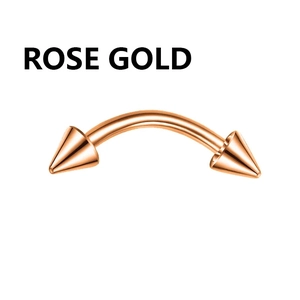 Close-up of a rose gold curved barbell with spike ends for eyebrow and nose piercing