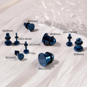 Dettaglio dei dilatatori per orecchie in acciaio blu con anelli in gomma nera in misure