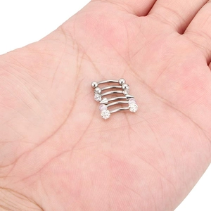Set of 5 curved stainless steel eyebrow rings with crystal, glitter, and ball ends held in hand