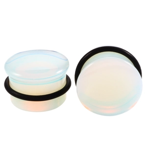 Detail view of white opal ear plugs with black O-ring rubber bands for ear stretching