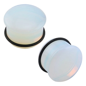 Macro shot of iridescent opal glass ear plugs with black rubber O-rings for piercing