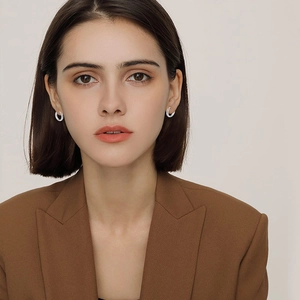 Silberne Edelstahl-Ohrringe an einem Modell für Maßstab und eleganten Business-Stil gezeigt