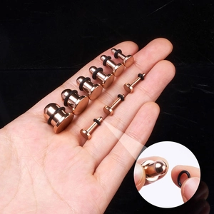 Dettaglio macro di dilatatori auricolari in acciaio oro rosa con anelli in gomma neri