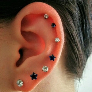 Detailed view of stainless steel labret set with star and heart shapes on ear