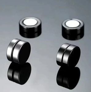 Macro detail of magnetic non-piercing stud earrings in black and silver finishes