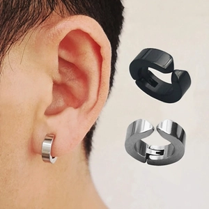 Close-up of minimalist stainless steel clip-on earrings in black and silver on male model