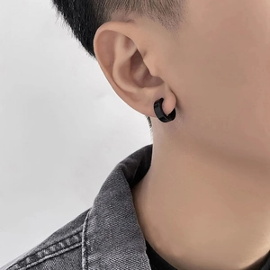 Close-up of black stainless steel clip-on hoop earring worn by a male model