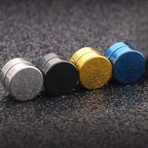 Dettaglio di quattro orecchini magnetici opachi nei colori argento, nero, oro e blu