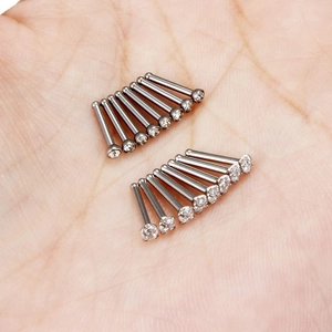 Set de 12 piercings para la nariz de acero inoxidable con circonitas blancas en una palma