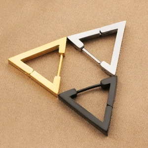 Macro view of geometric triangle earrings in gold, silver, and black polished steel