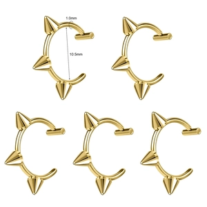 Detail of five 1.0mm gold stainless steel C-shaped punk lip rings with three sharp spikes