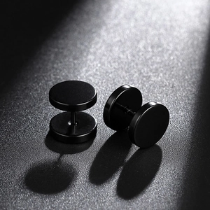 Close-up of black stainless steel dumbbell stud earrings with matte industrial finish