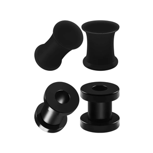 Detail of black stainless steel ear gauge set with matte solid plugs and hollow tunnels