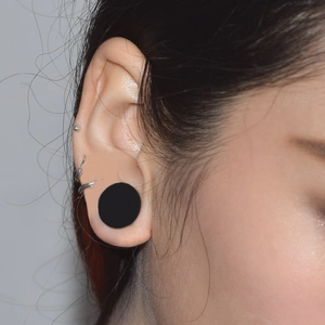 Set of 12 pairs of silicone flesh tunnels with silver hoop earrings on model ear