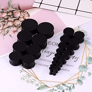 Detailed set of black silicone ear gauges in multiple sizes from small to large scale