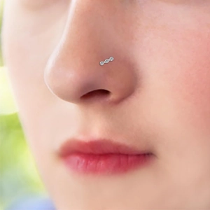 9-piece stainless steel nose ring set featuring triple CZ stone stud on a model