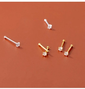 Detailed view of 4-prong zircon nose studs in gold and silver stainless steel options