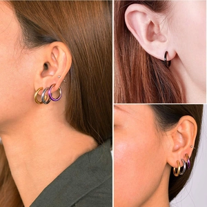 Détail des boucles d'oreilles créoles en acier inoxydable en or, noir et arc-en-ciel