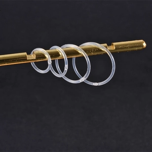 12-piece clear acrylic nose ring set in four sizes on a gold rod with black background