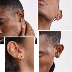 Détail macro de boucles d'oreilles vis tricolores montrant la tête cruciforme et le filetage