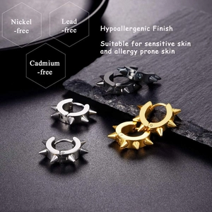Détail de boucles d'oreilles rivets punk en noir, argent et or en acier inoxydable